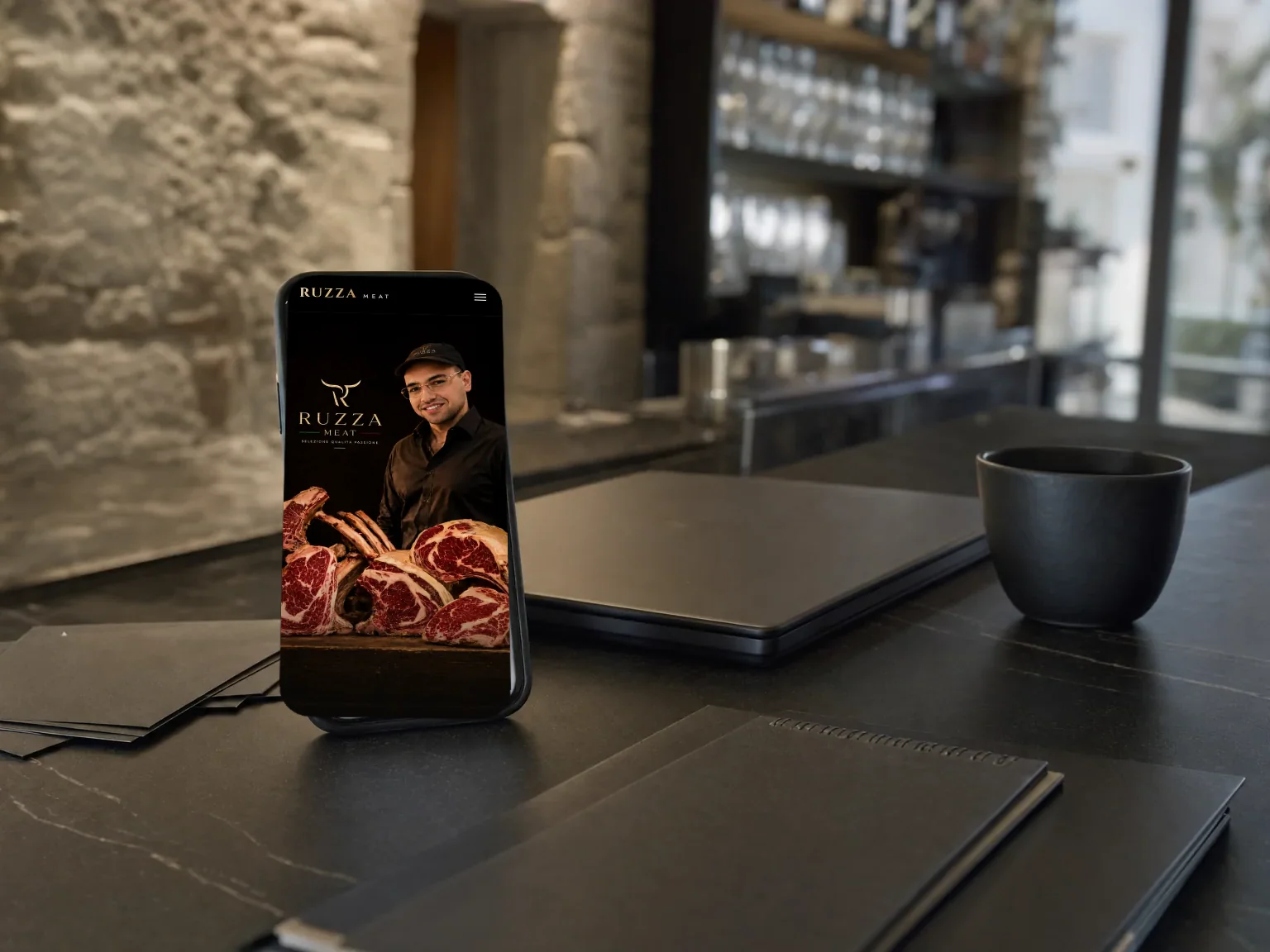 Phone on a venue counter, with the Ruzza Meat website open.